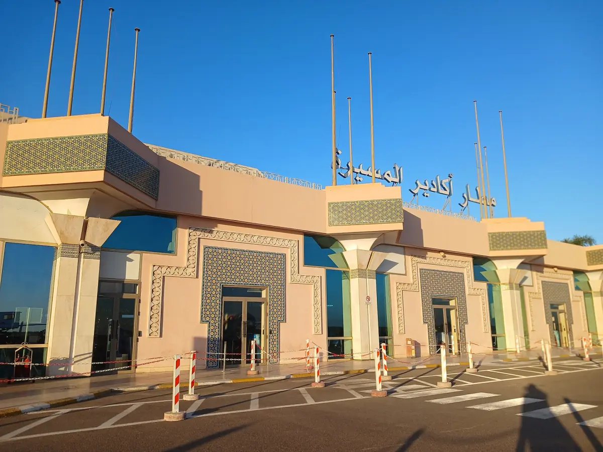 Terminal building of Agadir Al Massira airport with pink walls and blue glass in sunshine