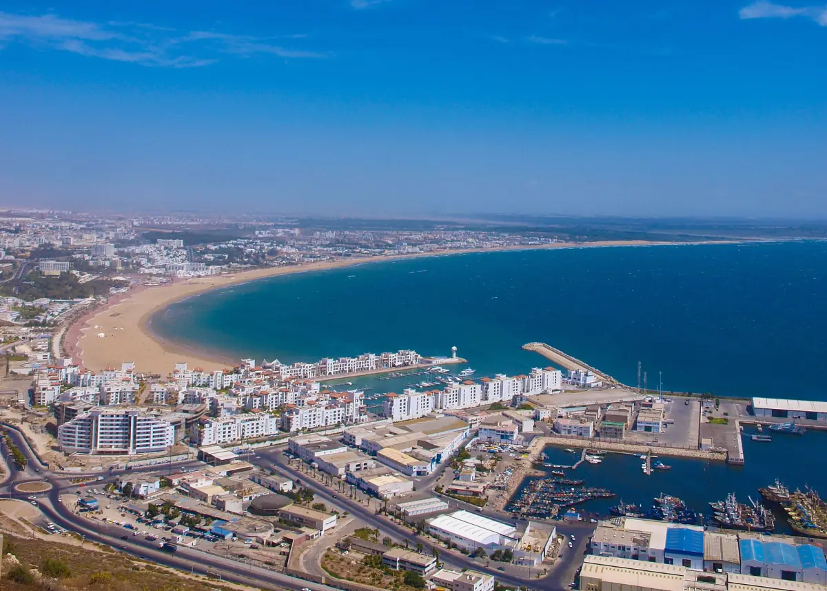 Aerial view of Agadir with the curved bay, long beach, harbour and city blocks