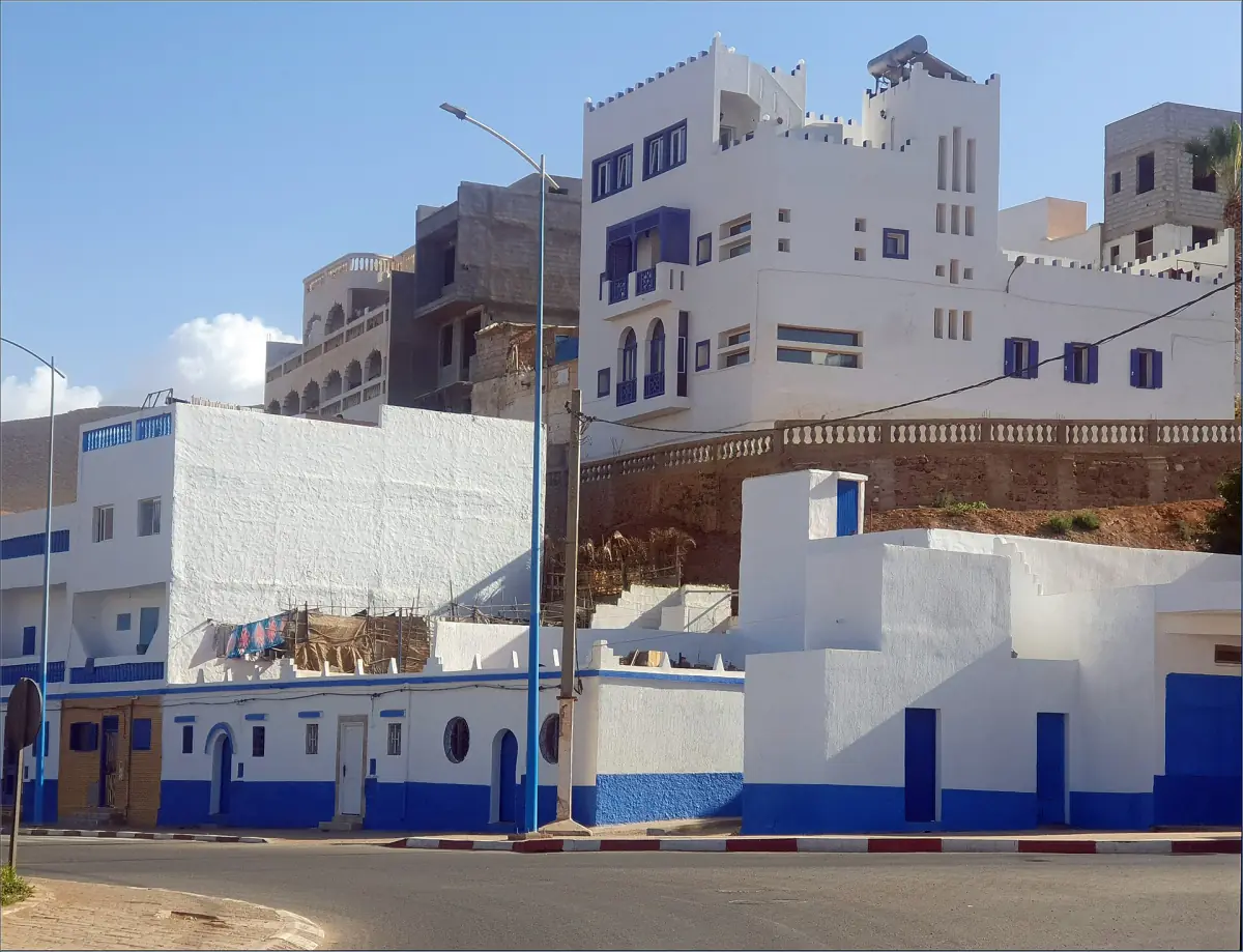 White and blue houses of Sidi Ifni stacked along a street corner